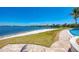 Scenic view from the poolside, featuring a sandy area by the lake and beautifully landscaped surroundings at 701 Maraviya Blvd, Nokomis, FL 34275