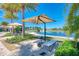 Relaxing poolside lounge area with sun umbrellas, chaise lounge and serene lake views providing a resort-like experience at 701 Maraviya Blvd, Nokomis, FL 34275
