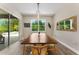 Dining room features a sliding glass door, large window, neutral walls, and a long wooden table with seating for eight at 7323 Great Egret Blvd, Sarasota, FL 34241
