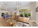 Spacious dining area with a large table, sliding doors to an outdoor space, and an adjacent modern kitchen at 7323 Great Egret Blvd, Sarasota, FL 34241