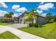 Charming home exterior with a well-manicured lawn, beautiful landscaping, and a brick-paved driveway at 7323 Great Egret Blvd, Sarasota, FL 34241