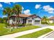 Charming one-story home featuring a tiled roof, a two-car garage, palm trees, and fresh landscaping at 7323 Great Egret Blvd, Sarasota, FL 34241