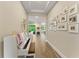 Light-filled hallway featuring a piano and a gallery wall leading to the main living spaces at 7323 Great Egret Blvd, Sarasota, FL 34241
