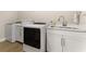 Functional laundry room featuring modern washer and dryer, and a utility sink at 7323 Great Egret Blvd, Sarasota, FL 34241
