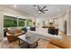 Open living room with a ceiling fan, large sliding glass doors to the outside, and modern decor at 7323 Great Egret Blvd, Sarasota, FL 34241