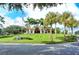 Beautiful clubhouse exterior surrounded by palm trees, lush landscaping, and well-manicured lawns at 7344 Villa D Este Dr, Sarasota, FL 34238
