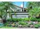 Elegant Villa D'Este community sign surrounded by lush tropical landscaping and colorful flowers at 7344 Villa D Este Dr, Sarasota, FL 34238