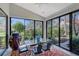 Bright dining area with a glass-top table, black metal chairs, and large windows offering garden views at 7344 Villa D Este Dr, Sarasota, FL 34238