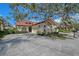 Charming home featuring a red tile roof, arched windows, and lush landscaping at 7344 Villa D Este Dr, Sarasota, FL 34238