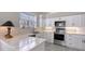 Modern white kitchen featuring stainless steel appliances and light marble countertops at 7344 Villa D Este Dr, Sarasota, FL 34238