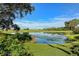 Beautiful view of a serene pond with a golf course in the background and lush, landscaped surroundings at 7344 Villa D Este Dr, Sarasota, FL 34238