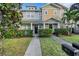 Two-story townhome with gray and tan siding, landscaping, and a walkway at 214 S Westland Ave # 1, Tampa, FL 33606