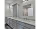 Double vanity bathroom with grey cabinets and quartz countertop at 9245 Zorn St, Port Charlotte, FL 33981