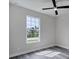 Bright bedroom with large window, ceiling fan, and grey vinyl flooring at 9245 Zorn St, Port Charlotte, FL 33981