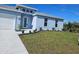 Single-story home with light blue exterior, white garage door, and well-manicured lawn at 9245 Zorn St, Port Charlotte, FL 33981