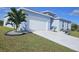 Newly built home with light blue exterior, white garage door, and neatly landscaped yard at 9245 Zorn St, Port Charlotte, FL 33981