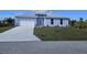 New single-story home with light blue exterior, white garage door, and landscaped lawn at 9245 Zorn St, Port Charlotte, FL 33981