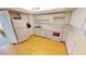Galley kitchen with white appliances and wood floors at 1 Colony Point Dr # 5C, Punta Gorda, FL 33950