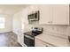 View of kitchen with white cabinets and stainless steel appliances at 1309 Nackman Rd, North Port, FL 34288