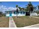 White single story home with teal accents and a walkway at 815 Conreid Ne Dr, Port Charlotte, FL 33952