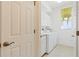 Bright laundry room with white cabinets, appliances, and window for natural light at 1871 Mossy Oak Dr, North Port, FL 34287