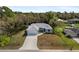 Aerial view of a charming home with an expansive driveway and beautifully landscaped surroundings at 825 Haleybury St, Port Charlotte, FL 33948