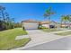 Two-car garage and driveway with green lawn at 2539 Thyme Way, North Port, FL 34289