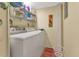 Bright laundry room with washer, dryer, and overhead storage at 3670 Bal Harbor Blvd # 1F, Punta Gorda, FL 33950