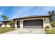 Front view of a single-story home with a brown roof and attached garage at 745 Columbia St, Port Charlotte, FL 33948