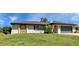 Single-story home with a brown roof, attached garage, and lush lawn at 745 Columbia St, Port Charlotte, FL 33948