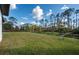An expansive backyard with lush grass and views of majestic pine trees at 5823 Kumquat Ave, North Port, FL 34291