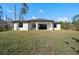 Back view of the house with a spacious covered patio and large backyard at 5823 Kumquat Ave, North Port, FL 34291