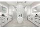 Luxurious bathroom with dual vanities, a soaking tub, and marble tile at 5823 Kumquat Ave, North Port, FL 34291