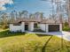 The home features a modern exterior with a dark roof, a two-car garage, and a landscaped front yard at 5823 Kumquat Ave, North Port, FL 34291