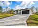Modern home with a paved driveway and a two-car garage at 5823 Kumquat Ave, North Port, FL 34291