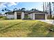 Modern home with a two-car garage and a manicured lawn at 5823 Kumquat Ave, North Port, FL 34291