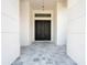 Inviting entrance featuring a stone-paved porch and elegant black double doors at 5823 Kumquat Ave, North Port, FL 34291