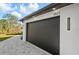 Close-up of the sleek dark garage door featuring modern lighting fixtures at 5823 Kumquat Ave, North Port, FL 34291