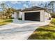 Modern home showcasing a dark garage door and stone-paved driveway at 5823 Kumquat Ave, North Port, FL 34291