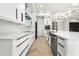 Sleek modern kitchen with white cabinets, quartz countertops, and stainless steel appliances at 5823 Kumquat Ave, North Port, FL 34291
