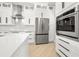 Beautiful kitchen showcasing stainless steel refrigerator, quartz countertops, and white cabinets at 5823 Kumquat Ave, North Port, FL 34291