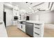 Close-up of a modern kitchen island with stainless steel appliances and white cabinetry at 5823 Kumquat Ave, North Port, FL 34291