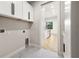 Open concept laundry room with white cabinets and marble tile flooring at 5823 Kumquat Ave, North Port, FL 34291