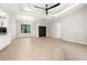 Spacious living room showcasing tray ceilings, modern fan, and light hardwood floors at 5823 Kumquat Ave, North Port, FL 34291