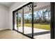 Spacious patio featuring sliding glass doors with beautiful green backyard view at 5823 Kumquat Ave, North Port, FL 34291