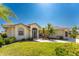 Single-story home with tile roof, landscaped lawn, and palm trees at 16446 Belo Ct, Punta Gorda, FL 33955