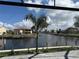 A picturesque canal view with palm trees, lush landscaping, and neighboring homes at 1426 Mineo Dr, Punta Gorda, FL 33950
