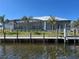 Stunning waterfront home featuring a screened-in lanai, private dock, and lush tropical landscaping at 1426 Mineo Dr, Punta Gorda, FL 33950