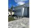 A modern white house with a metal roof, minimalist landscaping, and a paved driveway with stone pavers at 1426 Mineo Dr, Punta Gorda, FL 33950