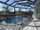 A serene pool area with a screened enclosure, stone pavers, and a tranquil canal view at 1426 Mineo Dr, Punta Gorda, FL 33950